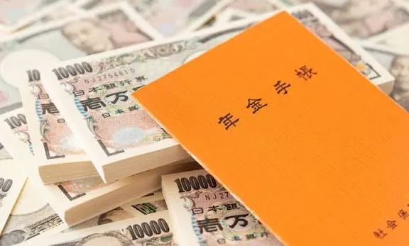 Japanese pension handbook resting on bundles of 10,000 yen notes, showing a five-year Japan pension lump-sum payout
